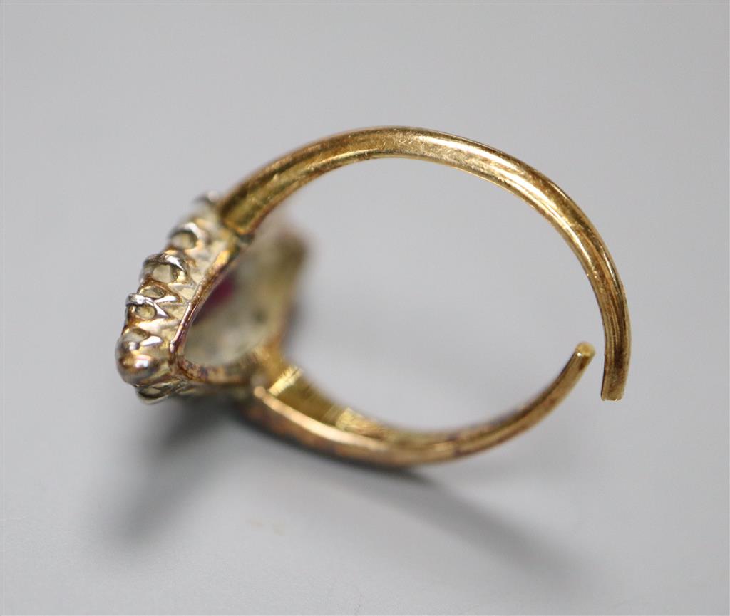 A yellow metal, ruby and diamond cluster set marquise shaped dress ring, shank has been cut and misshapen, gross 4.1 grams.